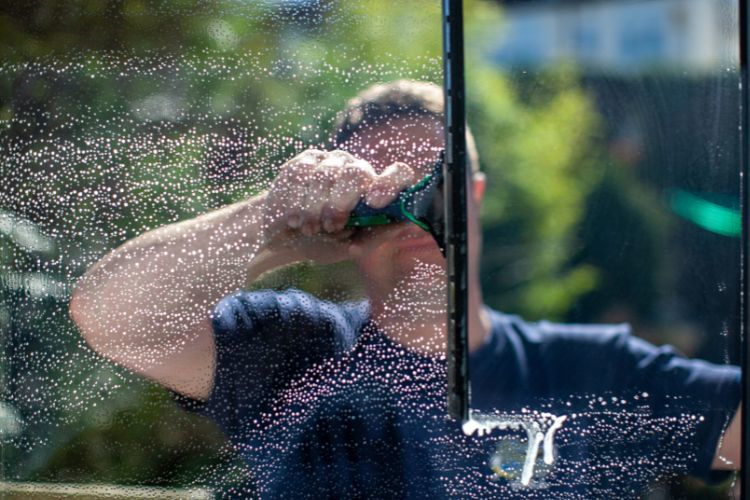 Man wast raam met een trekker