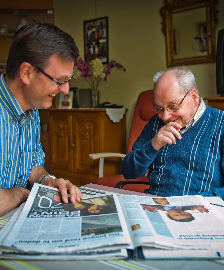 Foto van 2 mensen die samen de krant lezen
